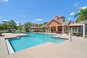 A large swimming pool in front of a house.